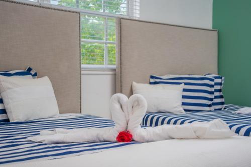 a bedroom with two beds with towel animals on them at SoBe Lux Suites On Ocean in Miami Beach