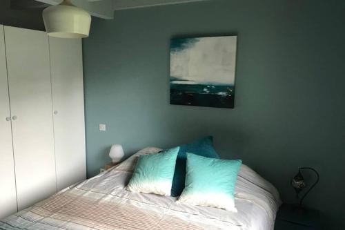 a bedroom with a bed with blue and white pillows at Spa et détente au cœur de la forêt des Landes - 3 étoiles in Luglon