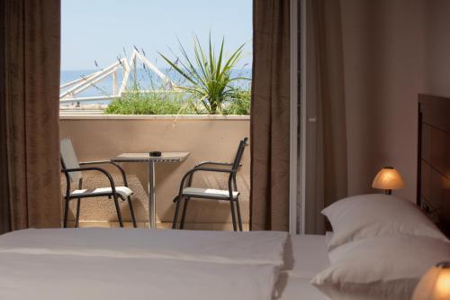 a bedroom with a bed and a balcony with a table and chairs at Apartments Agava in Makarska