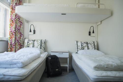two beds in a room with a backpack between them at Slottsskogens Hostel in Gothenburg