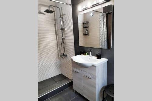W łazience znajduje się biała umywalka i prysznic. w obiekcie Etoile apartment w mieście Perissa