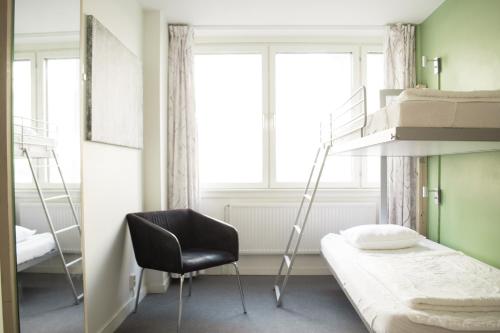 a bedroom with a bunk bed and a chair at Slottsskogens Hostel in Gothenburg
