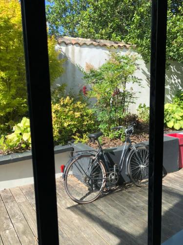 uma bicicleta estacionada ao lado de uma janela em Les voiles rouges em Saint-Martin-de-Ré