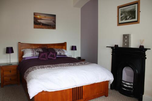 1 dormitorio con 1 cama y chimenea en No2 Abbey View Apartment, en Whitby
