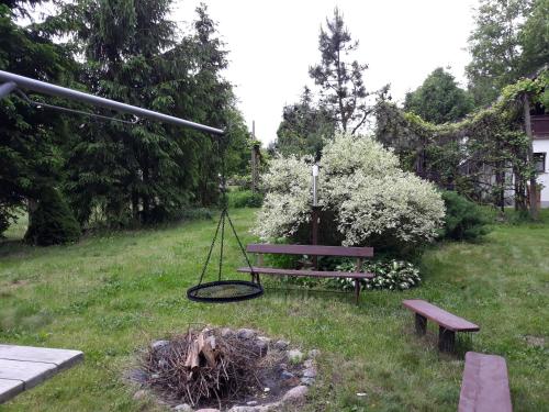 a park bench and a swing in a yard at Chata Białobrzeg in Białobrzeg Dalszy