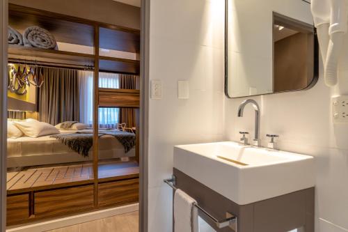a bathroom with a sink and a bedroom at Up Congreso Hotel in Buenos Aires