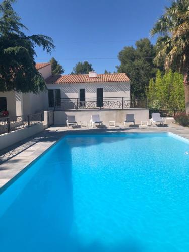 une piscine devant une maison dans l'établissement Grande propriété avec Piscine et Terrain de tennis privés, aux Lecques