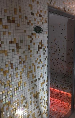 a tiled bathroom with a shower with a mirror at Spa et détente au cœur de la forêt des Landes - 3 étoiles in Luglon
