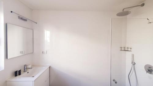 a white bathroom with a sink and a shower at BnB Israel Apartments - Shalom Alehem Joie in Tel Aviv