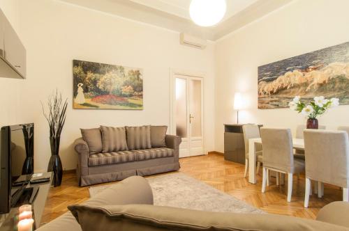 sala de estar con sofá y comedor en Milan Royal Suites - Centro Cadorna, en Milán