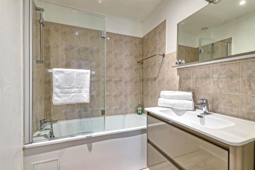 a bathroom with a tub and a sink and a shower at Gîte La Vapillone Paris Marne-la-Vallée in Serris