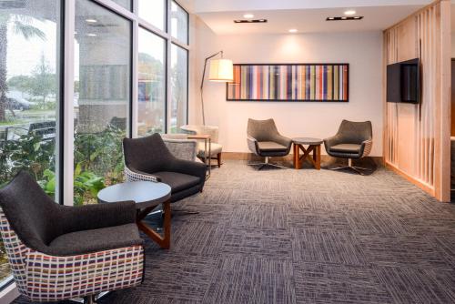a waiting room with chairs and a tv and windows at Holiday Inn Express & Suites - St. Petersburg - Madeira Beach by IHG in St. Petersburg
