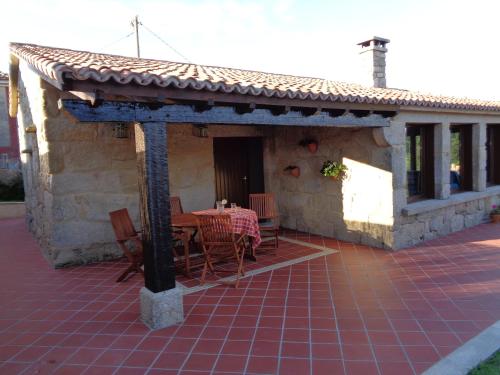une maison avec une table et des chaises sur une terrasse dans l'établissement casa rústica Cabo Home, à Cangas