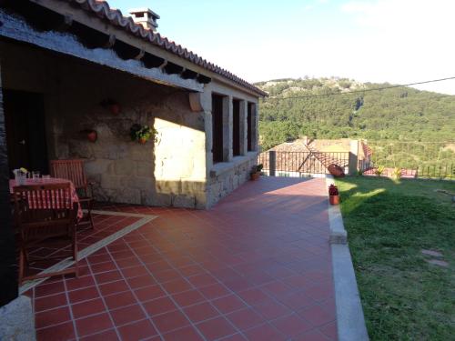 a patio outside of a house with a table and chairs at casa rústica Cabo Home in Cangas de Morrazo