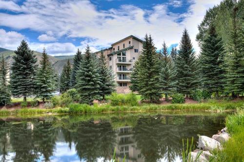 a building next to a lake with trees at GetAways at Falcon Point Resort in Avon