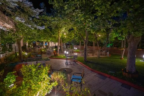 a park at night with chairs and tables and trees at Pantelidis Hotel & Spa in Ptolemaida