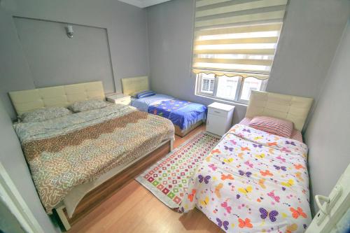 a small bedroom with two beds and a window at Amasra Kerem Apart in Amasra