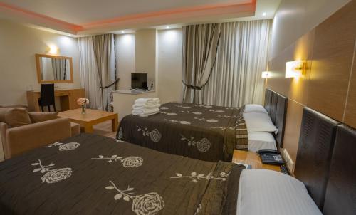 een hotelkamer met 2 bedden en een woonkamer bij Hotel Pantelidis in Ptolemaida