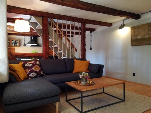 - un salon avec un canapé bleu et une table en bois dans l'établissement Wohlfühl Appartement - Kaisereinsde - traditionelles Lehmhaus Parken gratis, à Quedlinbourg