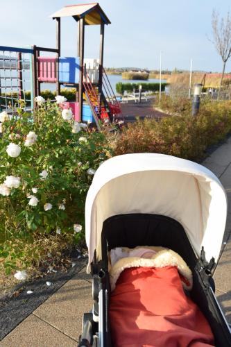 a baby stroller in front of a playground at Panorama Apartman in Velence