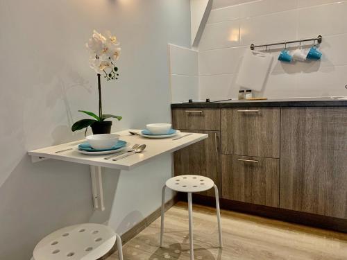 - une petite cuisine avec une table et deux tabourets dans l'établissement Mon petit nid d'amour au cœur historique de Fréjus, à Fréjus