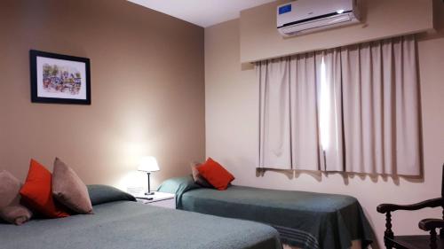 a hotel room with two beds and a window at Hotel Mirador de las Sierras in Villa Carlos Paz