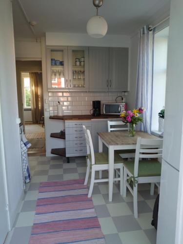 a kitchen with a table and chairs and a table and a kitchen at Vandrarhemmet Tallbacka/Ängelsberg Hostel in Ängelsberg