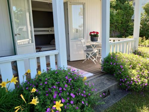a porch of a house with flowers at Vandrarhemmet Tallbacka/Ängelsberg Hostel in Ängelsberg