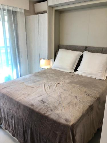 a bedroom with a large bed with white pillows at Studios Nice Gambetta in Nice