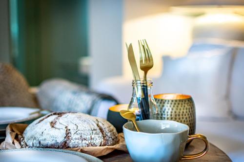 a table with a cup of coffee and a plate of bread at Onder de Linde B&B in Valkenburg