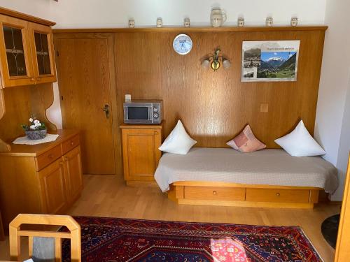a small bedroom with a bed and a microwave at Pension Schwemberger ohne Frühstück in Mayrhofen