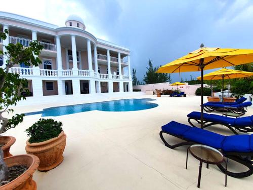 a patio area with chairs, tables and umbrellas at Ocean West Boutique Hotel in Nassau