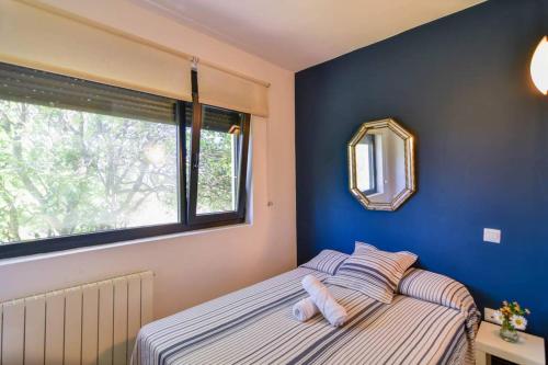 sypialnia z niebieskimi ścianami i łóżkiem z lustrem w obiekcie ¡Nuevo! Espectacular casa en la playa de Berria w mieście Santoña