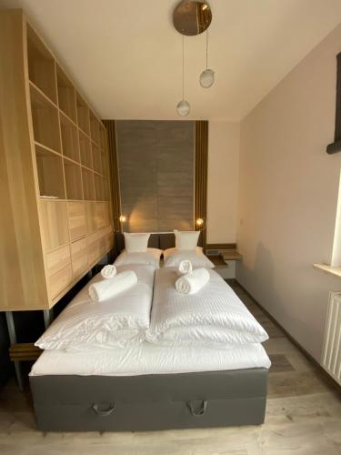 a bedroom with a bed with white sheets and towels at Apartament Drewno i Morze in Gdańsk