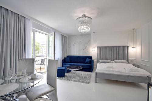 a bedroom with a bed and a blue couch at CRYSTAL Apartament 80m od plaży in Kołobrzeg