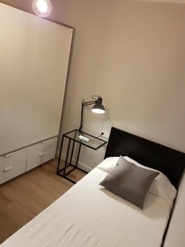 een slaapkamer met een bed met een lamp en een spiegel bij Precioso apartamento 3hab en Valencia (Benimaclet) in Valencia