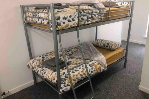 Łóżko piętrowe w pokoju z łóżkiem piętrowym w obiekcie Bee Hive Merthyr Tydfil w mieście Merthyr Tydfil
