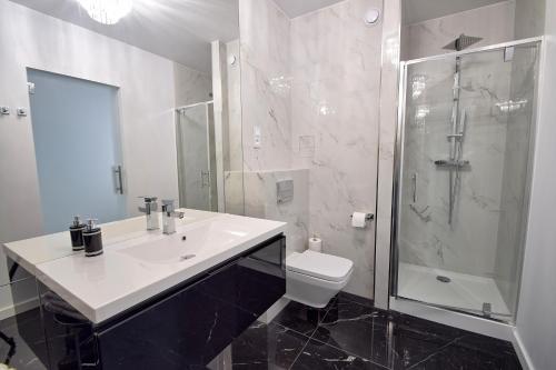 a bathroom with a sink and a shower and a toilet at CRYSTAL Apartament 80m od plaży in Kołobrzeg