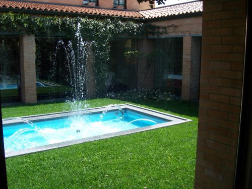 a swimming pool with a fountain in the yard at Villa Cavour in Bottanuco