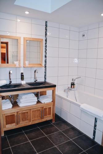 a bathroom with two sinks and a bath tub at Auberge de Savoie in Moutiers