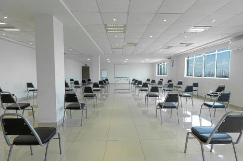 a large room with chairs and tables and windows at Hotel Plaza del Arco Express in Monterrey