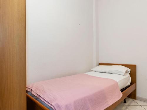a small bedroom with a bed with a pink blanket at Holiday Home in Lazise near Lake Garda in Lazise