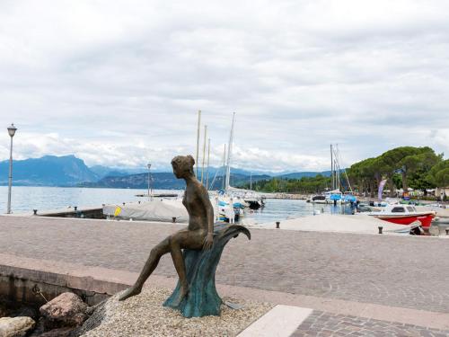 a statue of a woman sitting on a boat at Holiday Home in Lazise near Lake Garda in Lazise