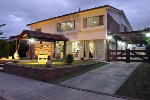 a house with a sign in front of it at Hotel Mirador de las Sierras in Villa Carlos Paz
