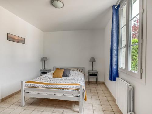a white bedroom with a bed and a window at Bronte s Coastal Retreat in Tracy-sur-Mer