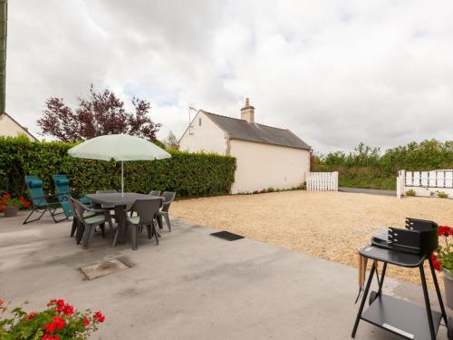 a patio with a table and chairs and an umbrella at Bronte s Coastal Retreat in Tracy-sur-Mer