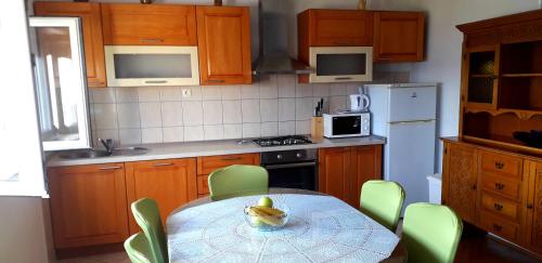 una cocina con mesa, sillas verdes y mesa y una cocina con en Mateo, en Dugi Rat
