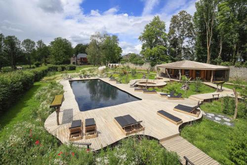 una vista aérea de una piscina con sillas y una casa en Domaine de Ronchinne - Maison du Jardinier, en Maillen