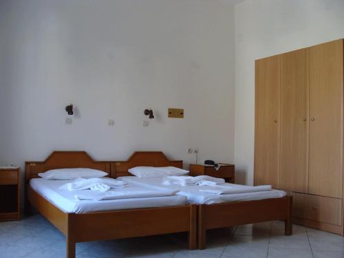 a bedroom with two beds with white sheets at Alexandra in Marathokampos