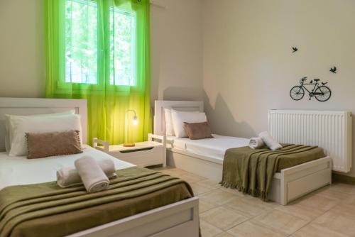 KatastárionにあるIonian Blissのベッドルーム1室(ベッド2台付)、壁に自転車1台が備わります。